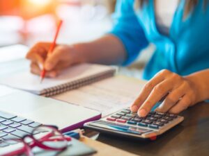 Woman Working With Calculator, Business Document And Laptop Computer Notebook