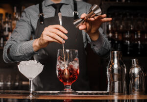 Barman Making An Alcoholic Drink With Ice In A Cocktail Glass