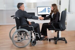 Businesswoman Shaking Hands With Disabled Businessman